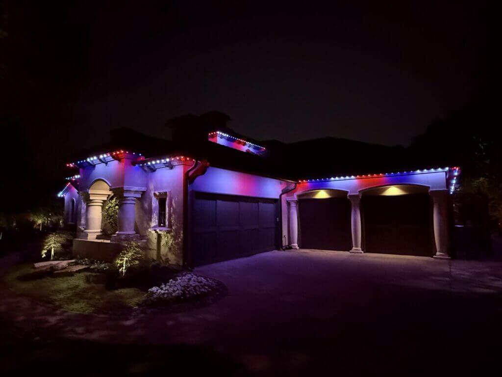 Home garage with multicolor permanent roofline lights at night