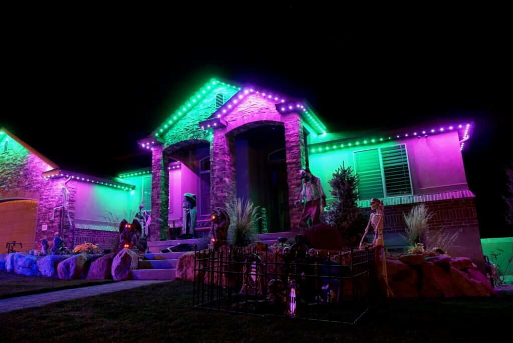 Home with purple and green Halloween permanent roofline lights