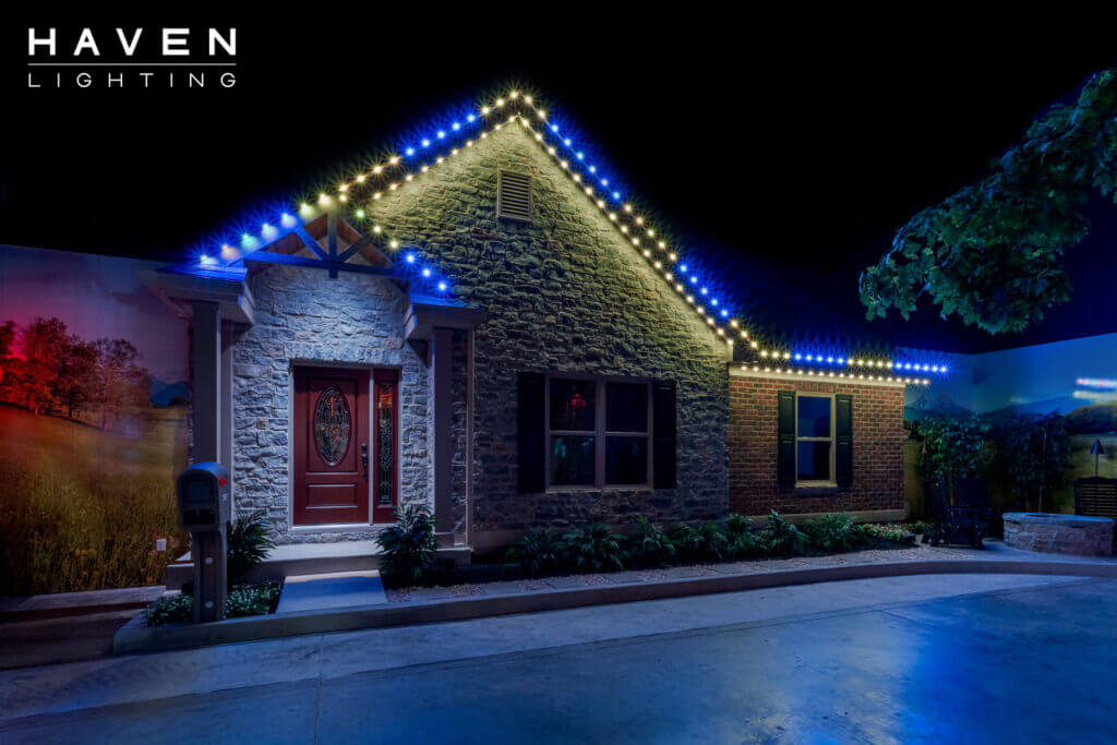 Single-story showroom home with blue multicolor permanent roofline and landscape lighting