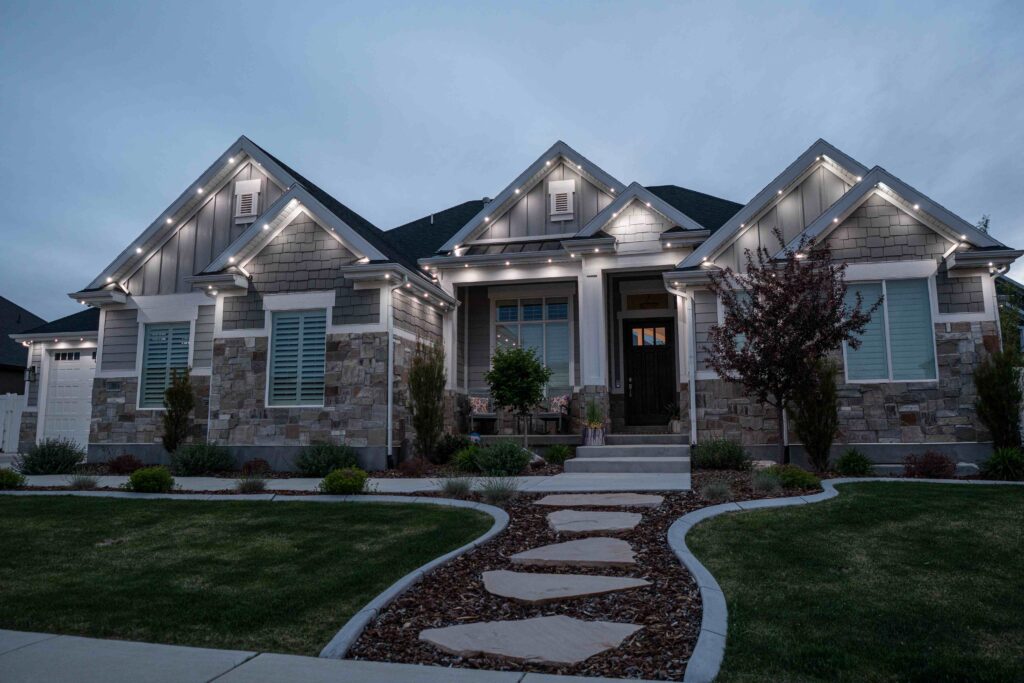Everyday warm white stone home with permanent outdoor lighting