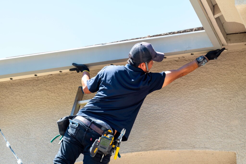 Happy Lites technician mounting permanent light track on the fascia