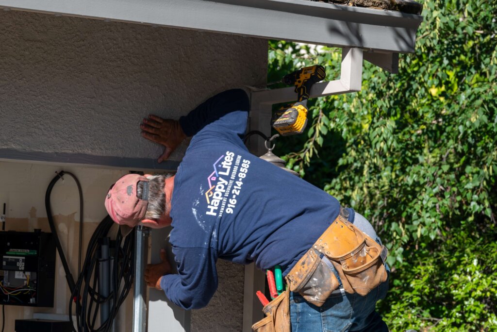 Close-up of a Happy Lites technician with tool belt during a permanent lighting install