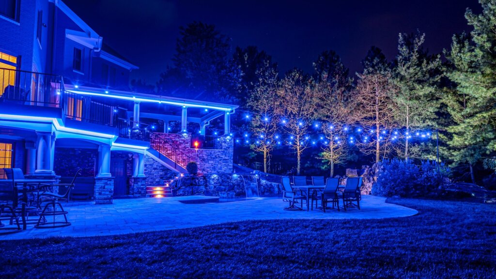 Backyard pool, patio and trees with blue pool permanent outdoor lighting