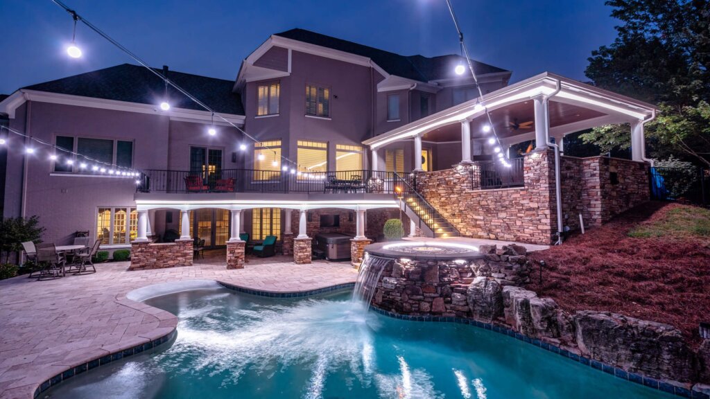 Backyard pool, patio and trees with pool white and blue permanent outdoor lighting