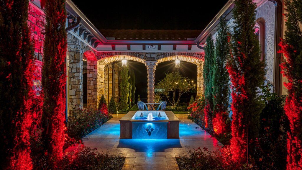 Estate courtyard and fountain with red permanent landscape lighting