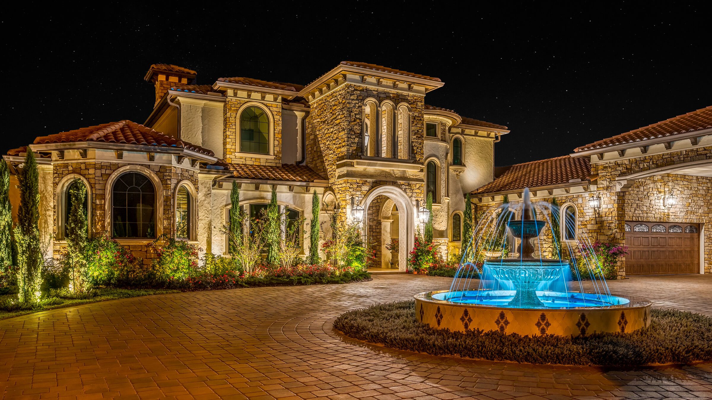 Estate front entry and fountain with warm permanent accent lighting