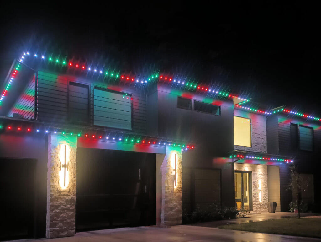 Garage with multicolor Christmas permanent roofline lights